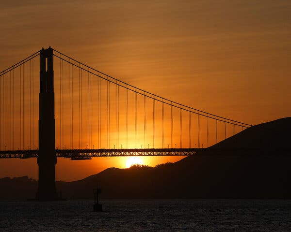 The sun sets behind the Golden Gate Bridge.