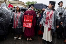 Kelly Hui, center, one of four students from whom the University of Chicago is withholding degrees because of their involvement in a protest encampment, at a rally after students walked out of the university’s convocation ceremony on Saturday.