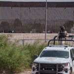 Migrants rested in the shade of the border wall between the United States and Juárez, Mexico.