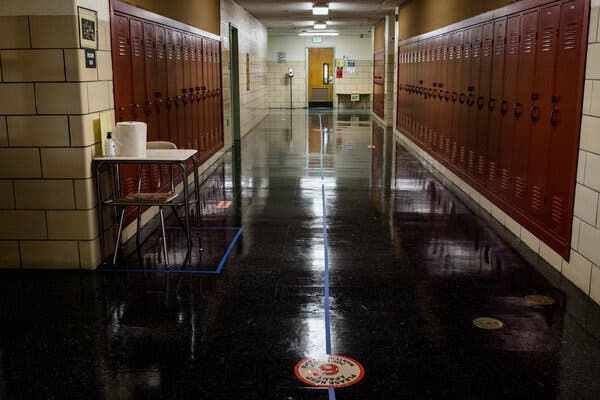 An empty school hall, lined with lockers.