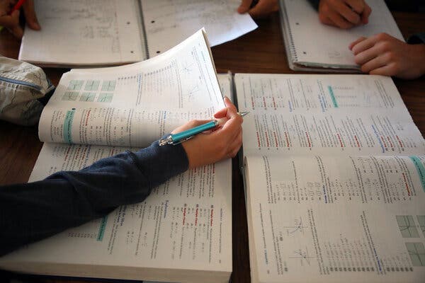 Open math textbooks and notebooks on a table.