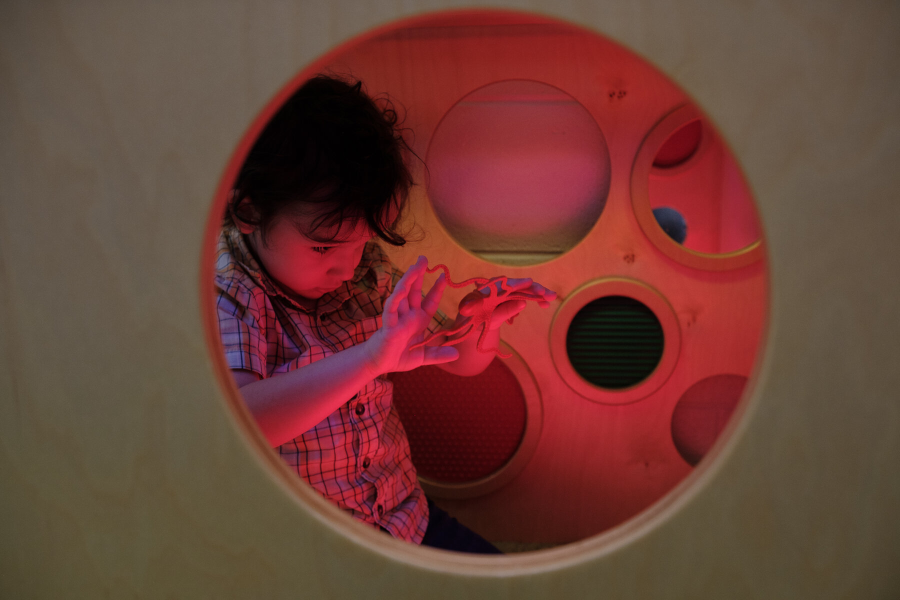 A child plays with a plastic toy with his fingers.