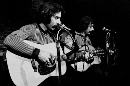 Happy Traum, left, in performance with his younger brother, Artie, at the Bitter End in Greenwich Village in 1970. The brothers performed at the Newport Folk Festival, toured the world and released five albums.