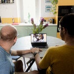 An Italian couple looking at an ultrasound scan from their American surrogate at home in July.