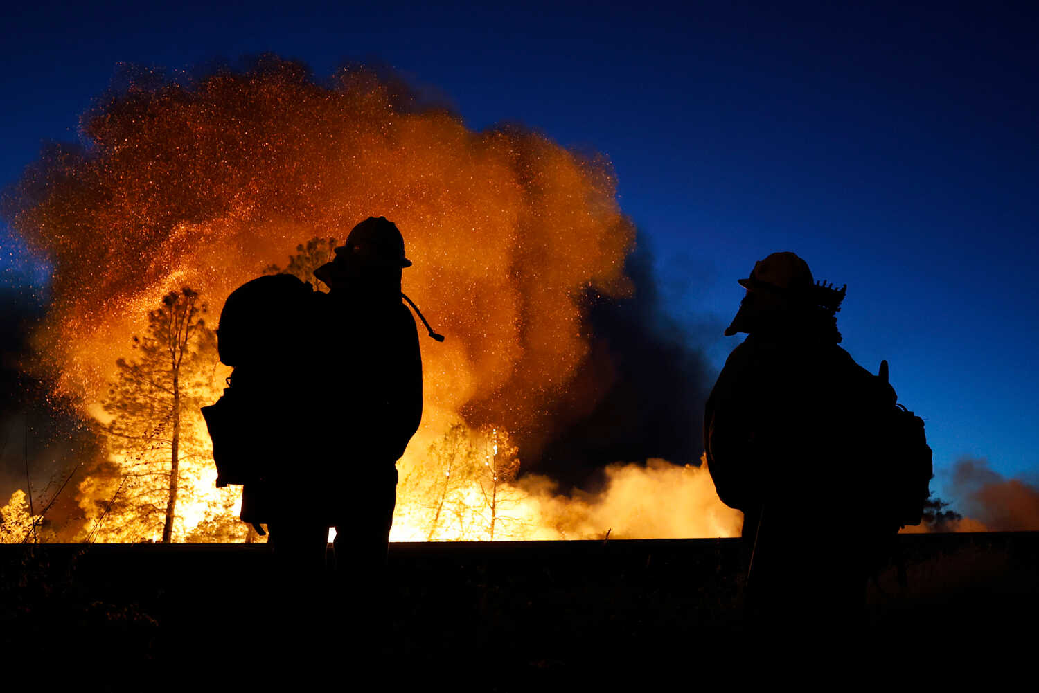 Firefighters watch as the Park Fire gets closer to highway 32 in Chico, Calif., on Thursday.