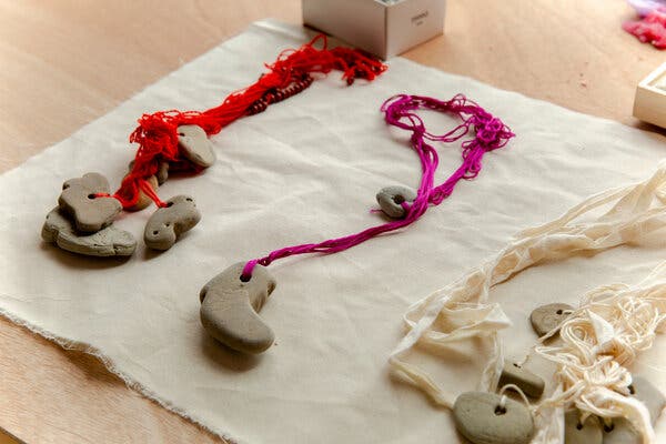 Talismans made from hag stones with yarn looped through the holes in the rocks.