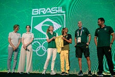 Yasmin Meichtry, third from left, of the Olympic Museum with the Brazilian gymnast Rebeca Andrade, who donated the leotard she wore during her silver medal-winning performance in the all-around competition.