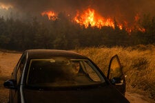 A local resident evacuated during a wildfire in Dione, Greece, on Monday.