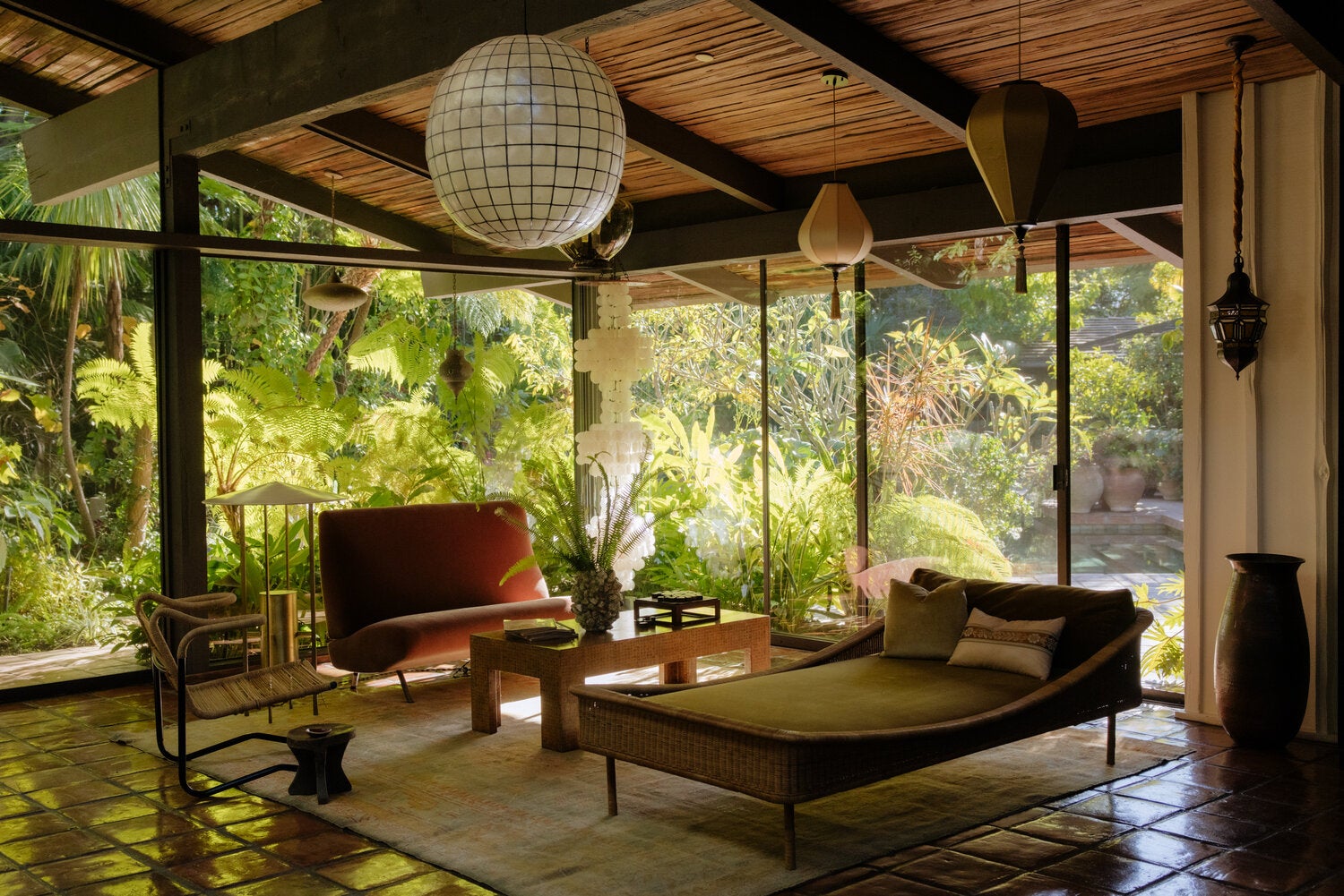 In the great room of Amy Pascal and Bernard Weinraub’s Los Angeles home, a 1955 Joseph-André Motte rattan daybed from Galerie Half and a 1957 Arflex sofa by Marco Zanuso, which is flanked by a Verner Panton shell light and a 1954 brass floor lamp by Philip Johnson and Richard Kelly. The decoupage coffee table was inherited from Pascal’s mother, Barbara Pascal, and the vintage rope chair is by Dan Johnson.