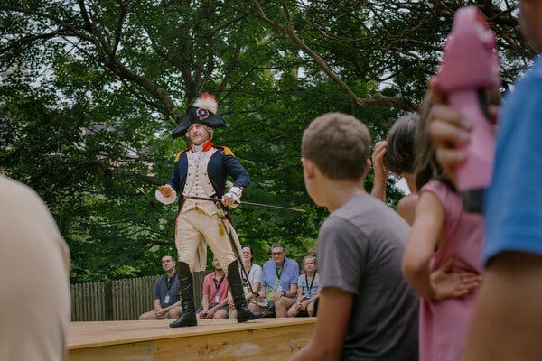 Mark Schneider, dressed as Lafayette, holds a sword in his left hand, as he talks to visitors at Colonial Williamsburg.