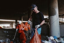 Gov. Gavin Newsom worked with Caltrans employees to pick up trash at a homeless encampment under a freeway in Los Angeles.