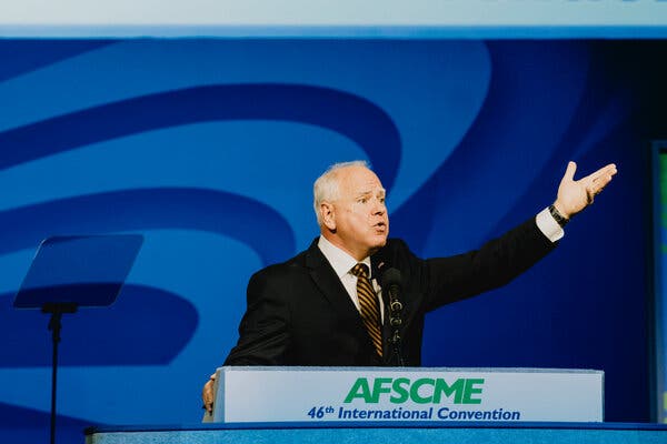 Gov. Tim Walz gesturing at a lectern.