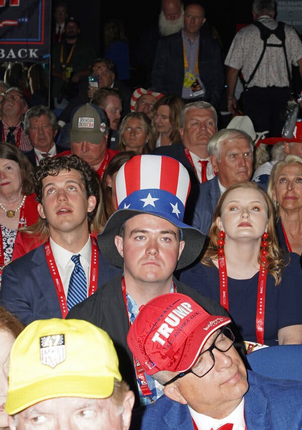 A group of people on the floor of the Republican convention, including a man with an Uncle Sam-style top hat. 