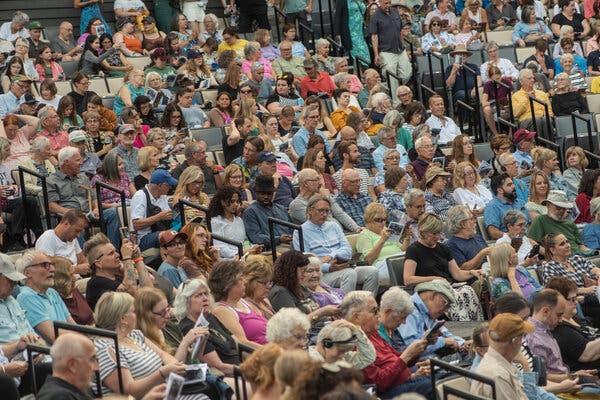 Theatergoers are sitting in their seats at an outdoor amphitheater in Wisconsin.