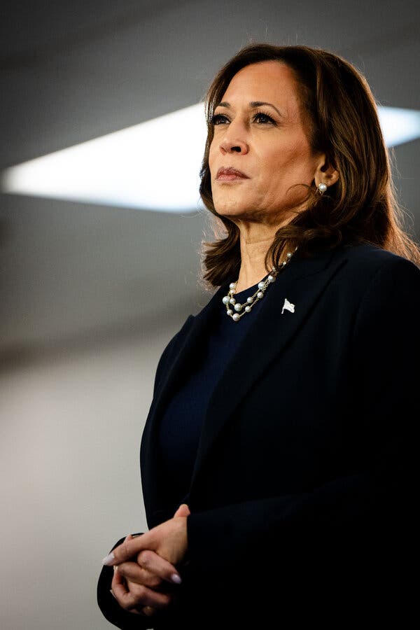 Vice President Kamala Harris wearing a black suit and pearl necklace.