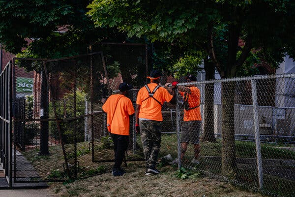 Workers stand near fencing.