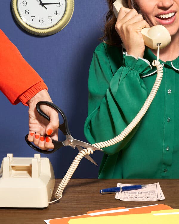 One person talking on a phone while another person’s hand, holding a pair of scissors, reaches in to cut the phone cord. 