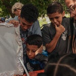 Amigos y familiares de Jeison Gabriel España, de 18 años, lloran durante su entierro. España falleció mientras protestaba en un barrio de bajos ingresos en Caracas.