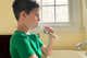 A child brushing their teeth with an electric toothbrush.