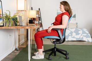 A person sits in the Steelcase Silq chair and leans back slightly.