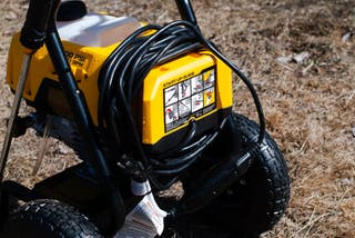 Close view of the black cord wrapped around the yellow body of the DeWalt DWPW2400 2400 PSI Electric Cold-Water Pressure Washer, our runner up for best pressure washer.