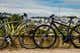 Two hybrid bikes, on from Jamis and one from Fuji, shown facing each other in front of a hilly landscape.