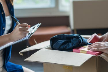 Young couple packing and checking stuff by using checklist before moving to new residence.