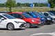 A row of cars parked in a parking lot on a sunny day.