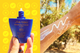 Close-up of a bottle of Shiseido Ultimate Sun Protector Lotion SPF 60+ and one of a person's arm with sunscreen on it, shown side by side.