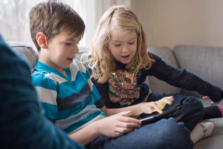 Two children looking at a tablet together.