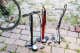 Three standing bike pumps on a cobble stone backyard.