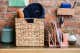 A wooden table with papers hats and keys organized using bins and shelves.